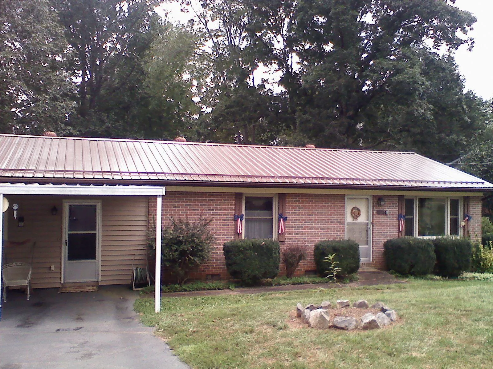 Bronze metal roof and carport on a brick ranch home — Roof Repair work by our crew in White Plains
